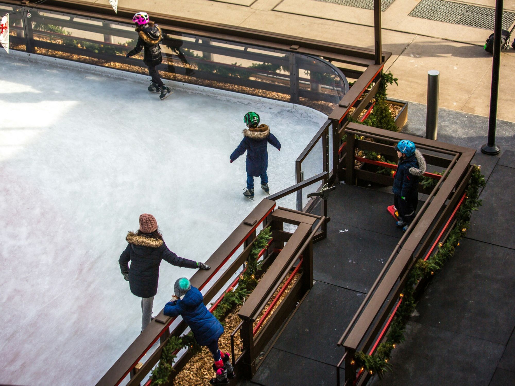 Ice skating på vintern: Barn och ungdomar på en skridskobana som har roligt och är aktiva.