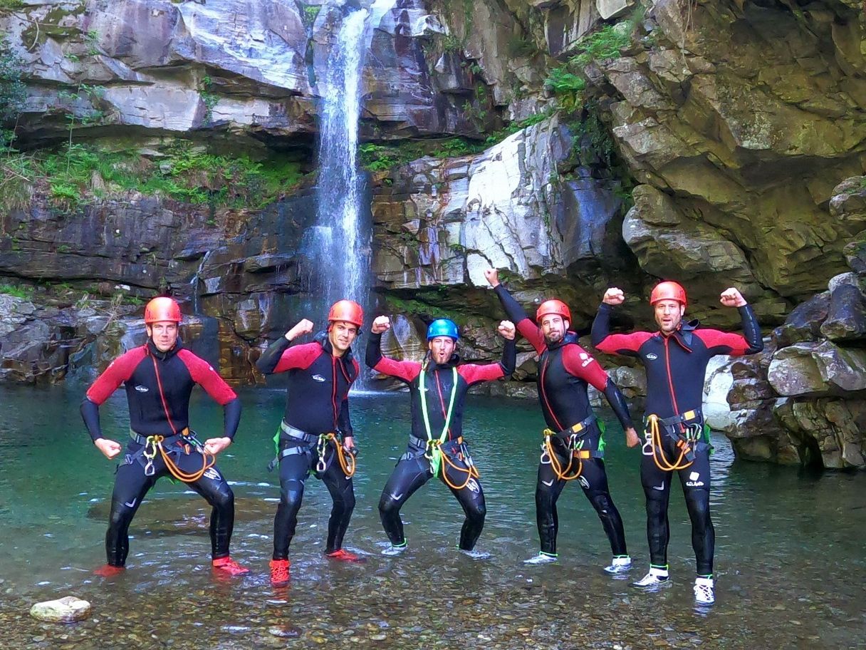 Kąpiele w kanioningu na poziomie podstawowym: grupa podczas kąpieli pod wodospadem, radość i przygoda na łonie natury.