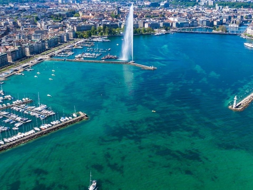 Fontanna Jet: imponujący strumień wody na Jeziorze Genewskim, otoczony miastem i łodziami.