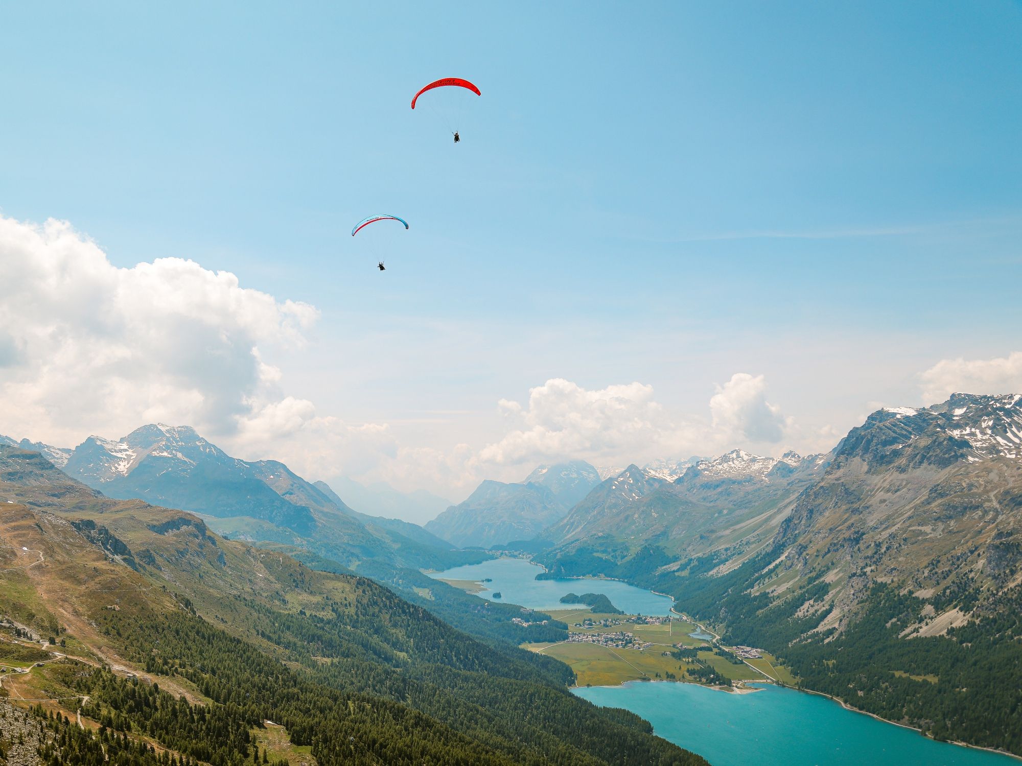 Engadin Paragliding: Genieße den Tandemflug über Samedan mit Blick auf die beeindruckenden Berge und Seen.