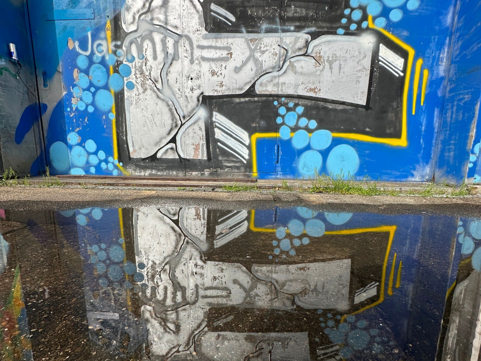 도시 환경의 벽에 있는 그래피티의 반사, 파란색 톤으로.