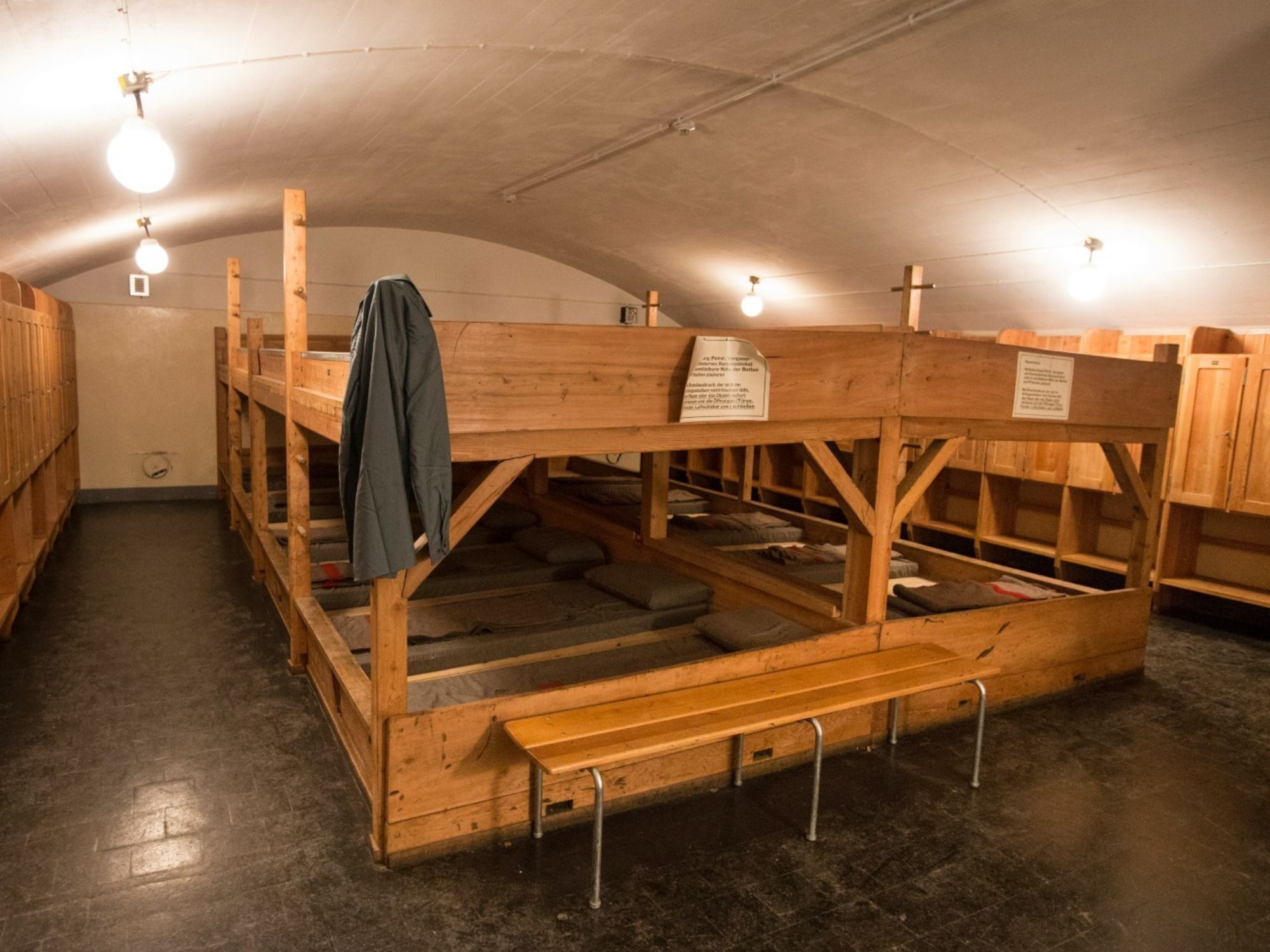 Forteresse historique : dortoir avec bancs en bois et matelas au San Gottardo, idéal pour les voyages de groupe.