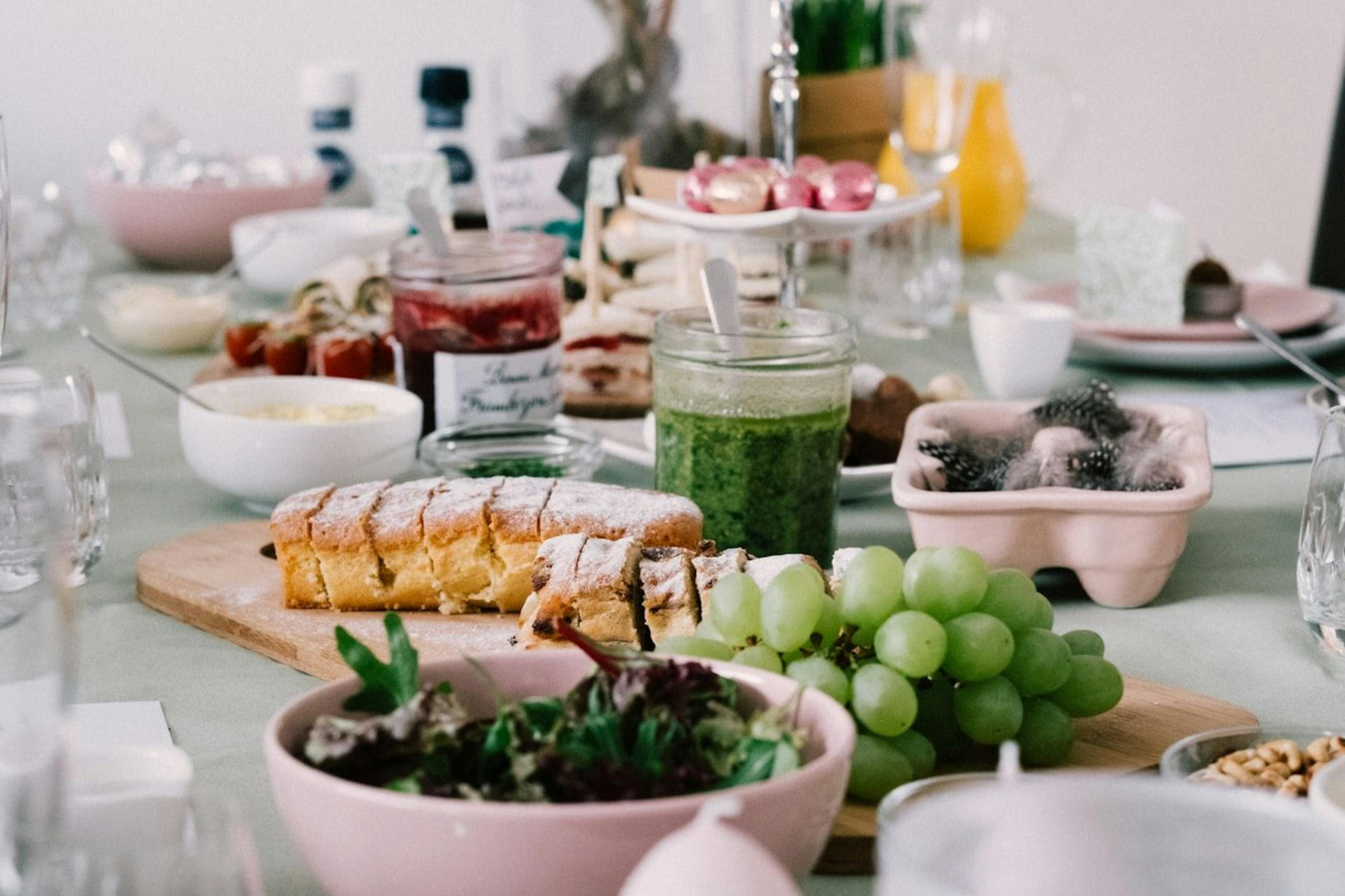 Brunch com vários pratos, uvas frescas e molhos.