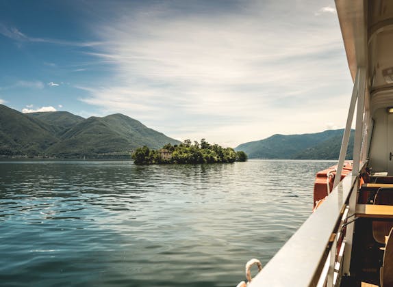 Locarno: Slap af ved søen med udsigt over den ensomme ø og de omkringliggende bjerge.
