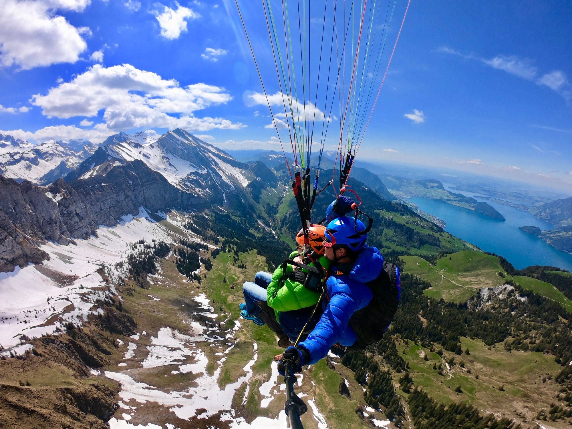 Paragliding in Luzern met uitzicht op bergen en het Vierwaldstättermeer in de zomer.