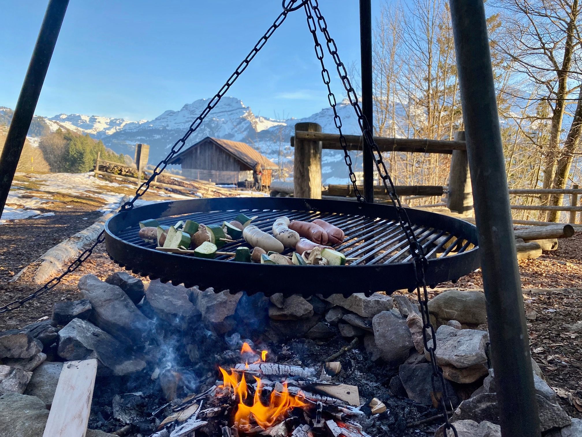 在大自然中烧烤：在梦幻的山景前享用烤香肠和蔬菜。