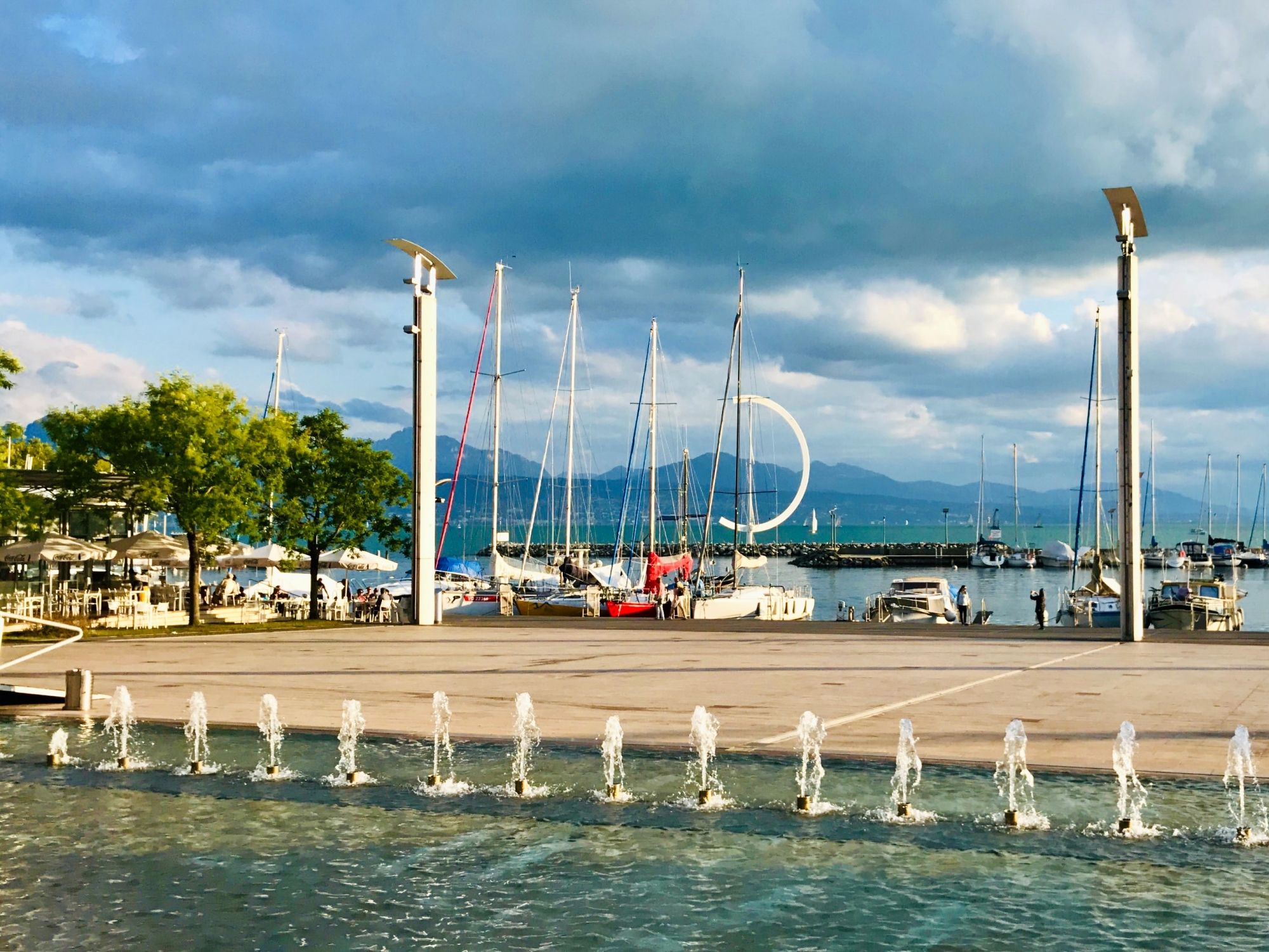 लॉज़ेन बंदरगाह पर नावें और जल फव्वारे