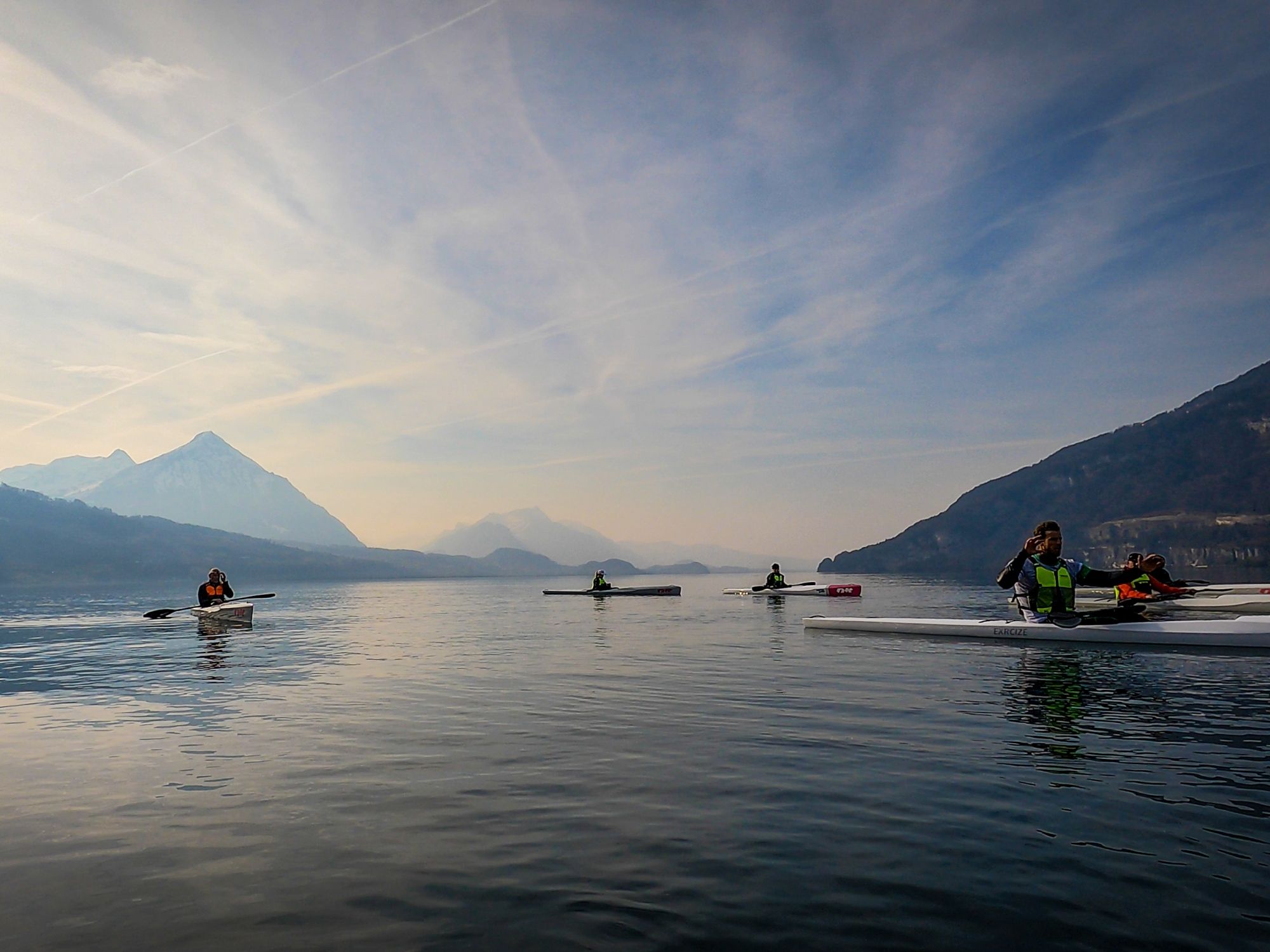 Cours de ski nautique sur le lac de Thoune avec une vue sur les montagnes et la surface d'eau calme.