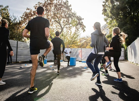 Gruppengymnastik: Fitness Training im Freien mit motivierten Teilnehmern und Equipment.