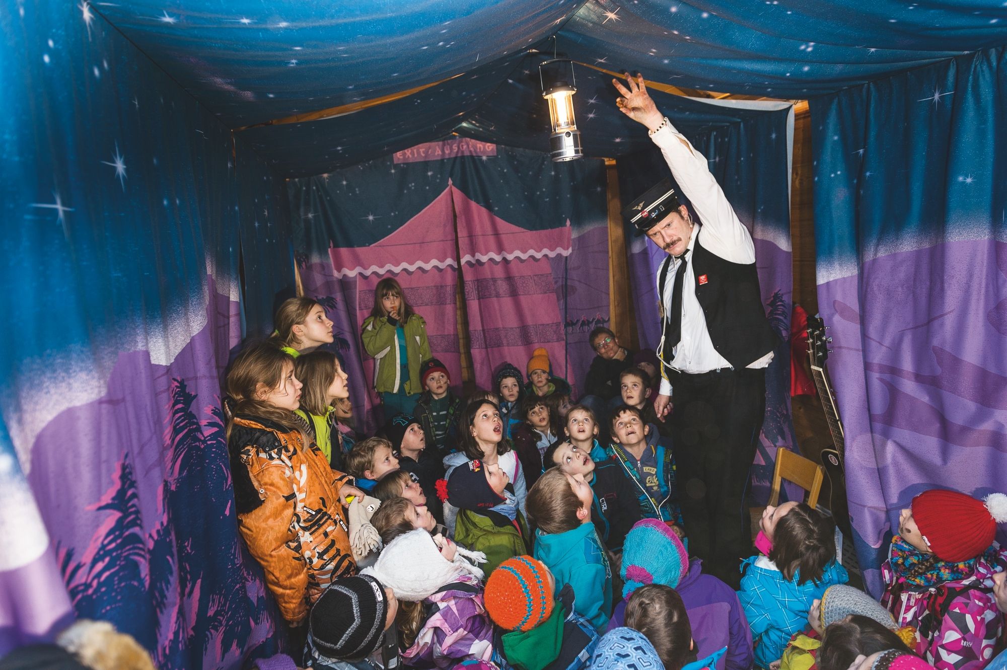 Lichtland avec Linard Bardill, les enfants sont captivés, représentation dans une atmosphère de tente colorée.