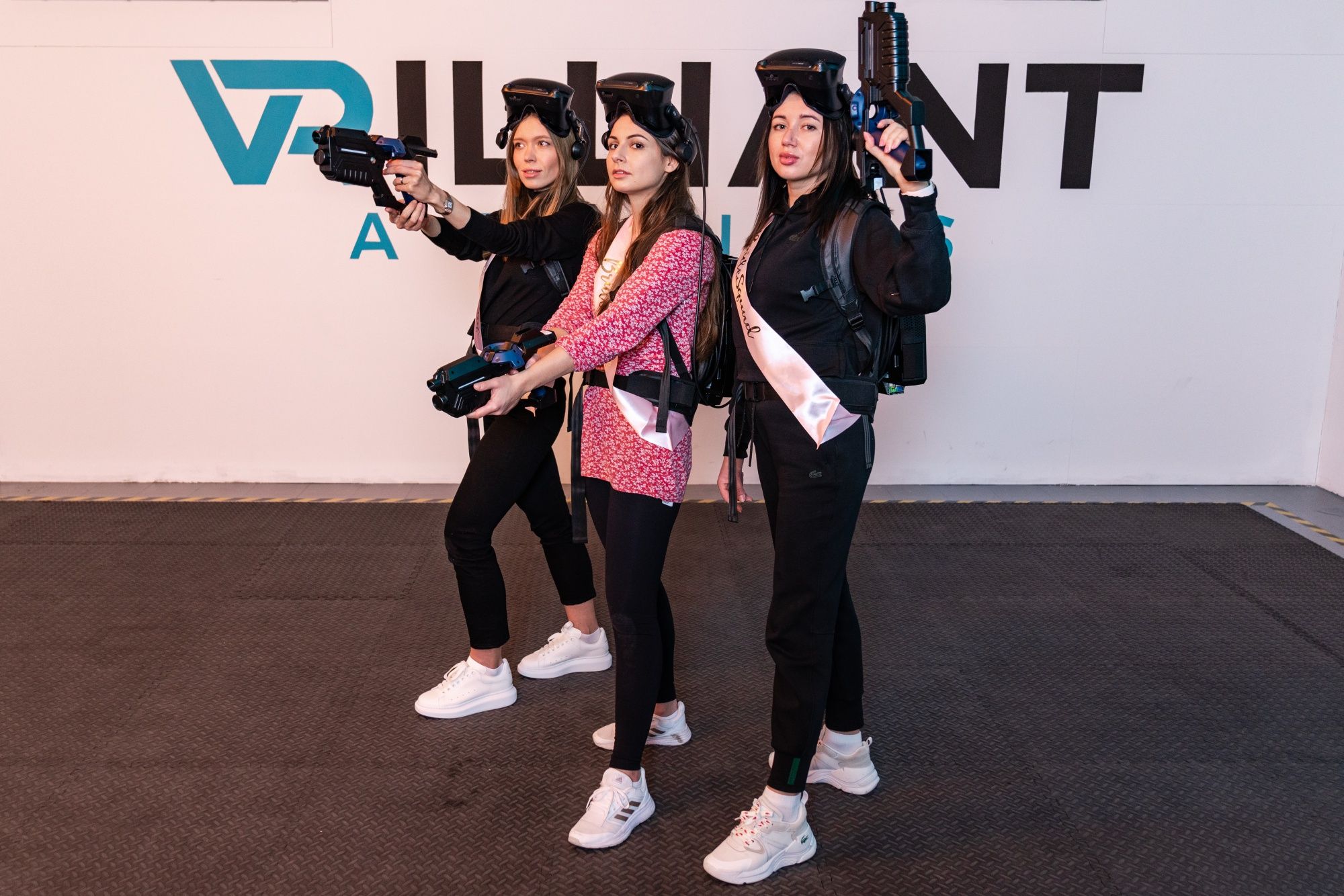 VR Archer: três jogadoras em realidade virtual com armas futuristas e espírito de equipa.