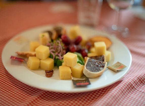 Cheese tasting Appenzell with different cheese pieces and grapes.