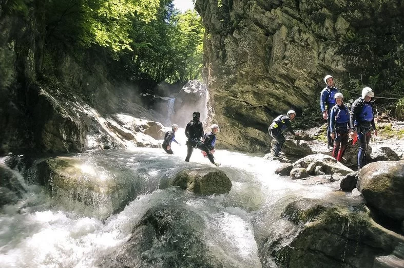 Canyoning Interlaken with participants in the water between rocks.