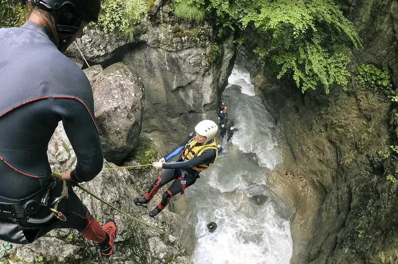 Canyoning Interlaken rappelling down rocks over raging water