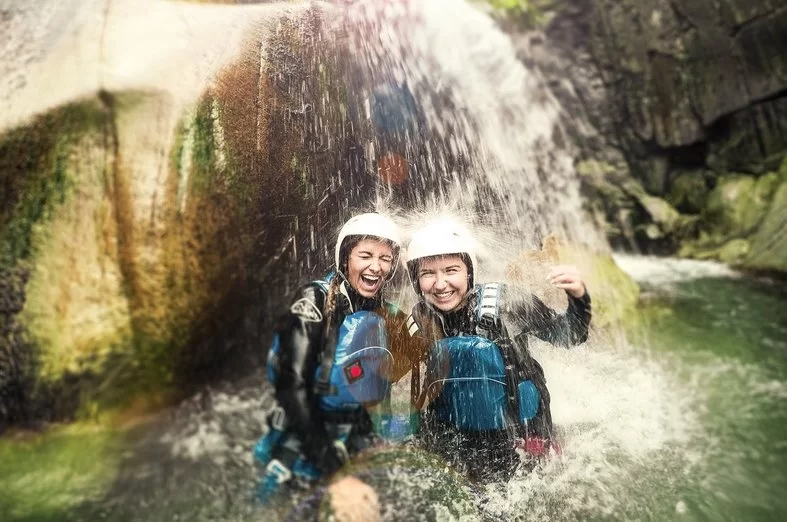 Canyoning Interlaken with swimmers under waterfall