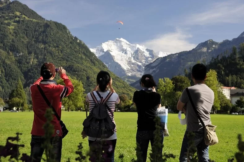 Interlaken paragliding with mountains in the background on a sunny day.