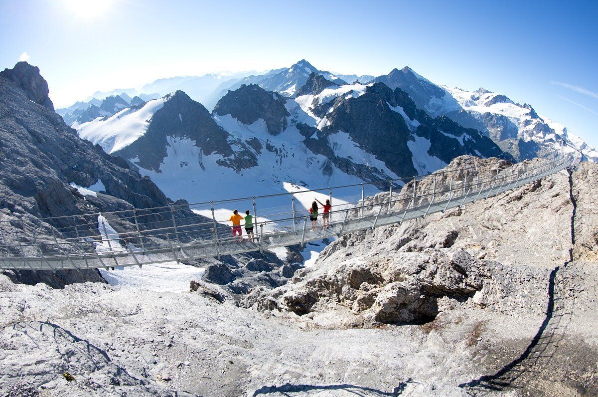 Titlis Erlebnisse, Wandernde Personen auf einem Wanderweg, atemberaubende Bergkulisse.