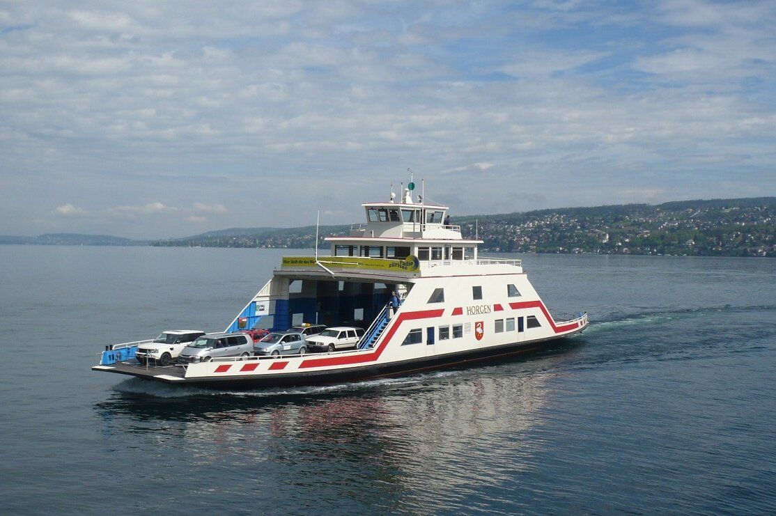 Ferry del Lago di Zurigo con auto nel Mittelland, superficie del lago calma e cielo nuvoloso