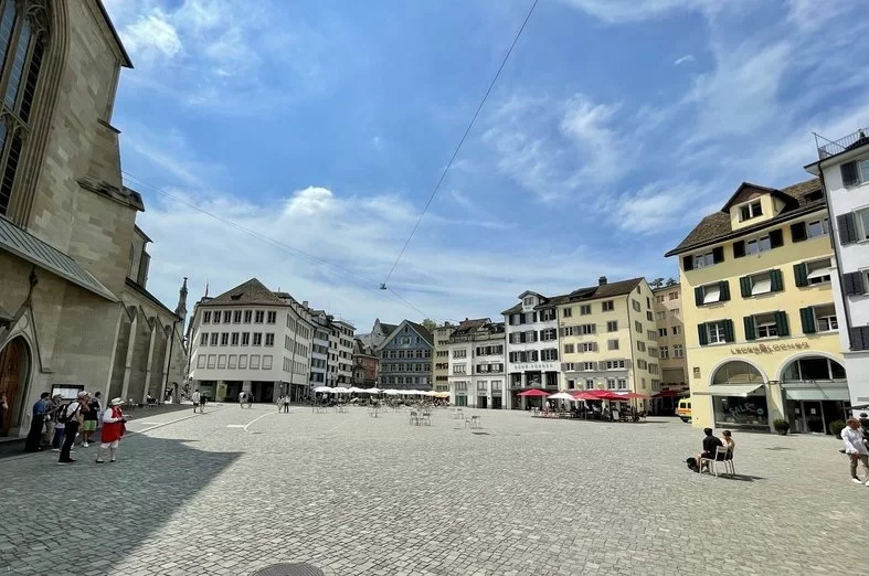 苏黎世老城区：穆尔斯特霍夫广场的历史建筑，周围有咖啡馆和露天的客人。