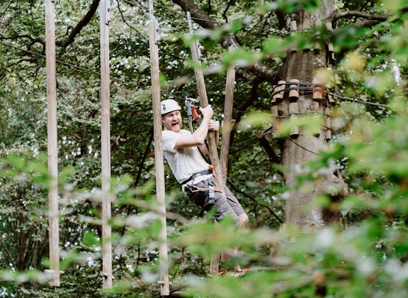 Seilpark Monte Tamaro: Erwachsener beim Seilrutschen in der Natur, perfekt für Abenteuer und Gruppenaktivitäten