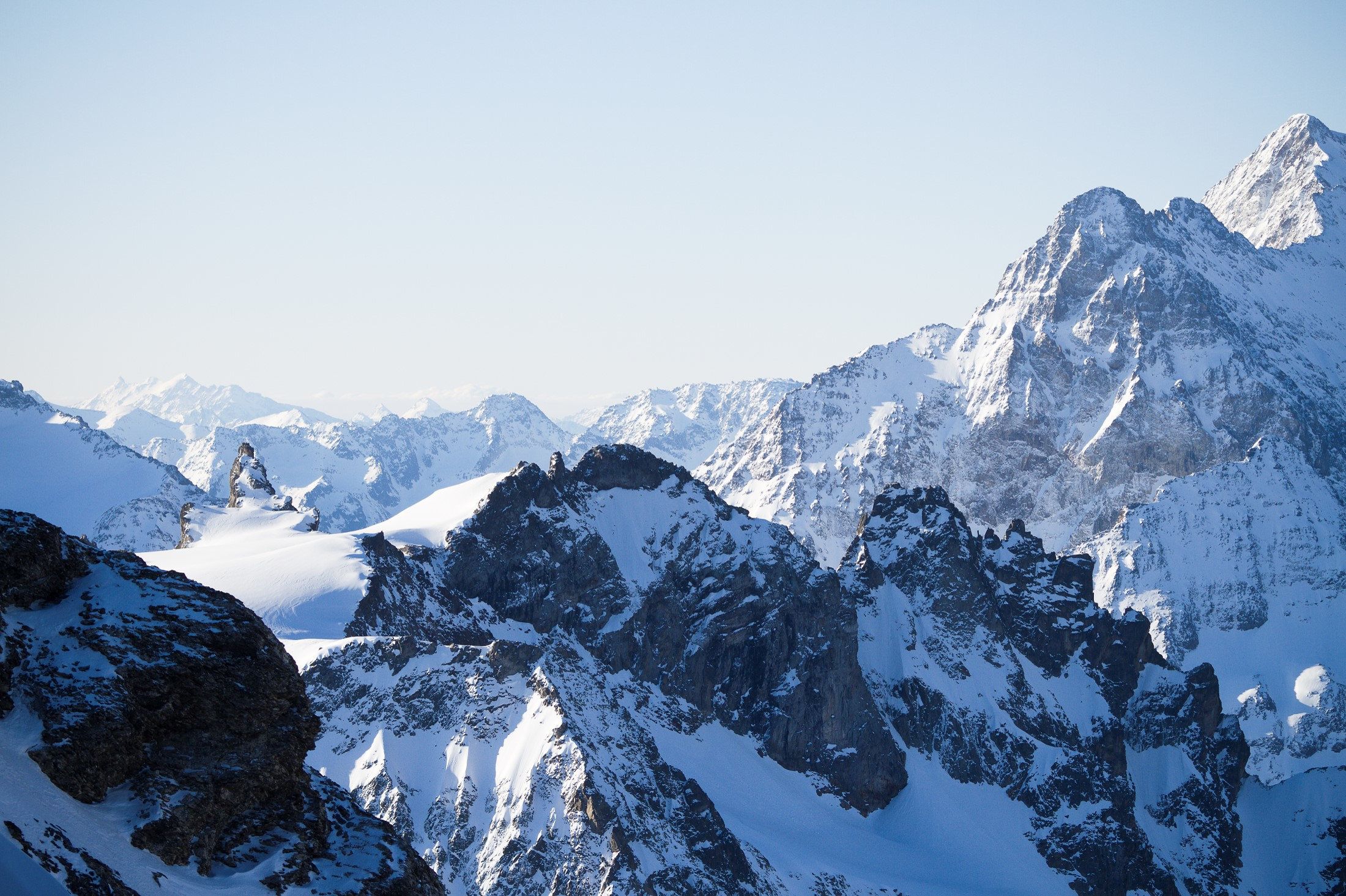 Bergtop: Panoramisch uitzicht vanaf de Titlis met besneeuwde bergen en een heldere lucht, ideaal voor zomerse wandelingen.