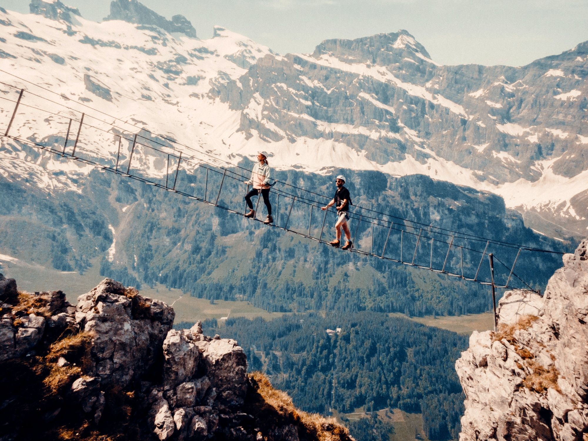 Via Ferrata: Enjoy the thrilling crossing of the bridge with mountain scenery in the background.