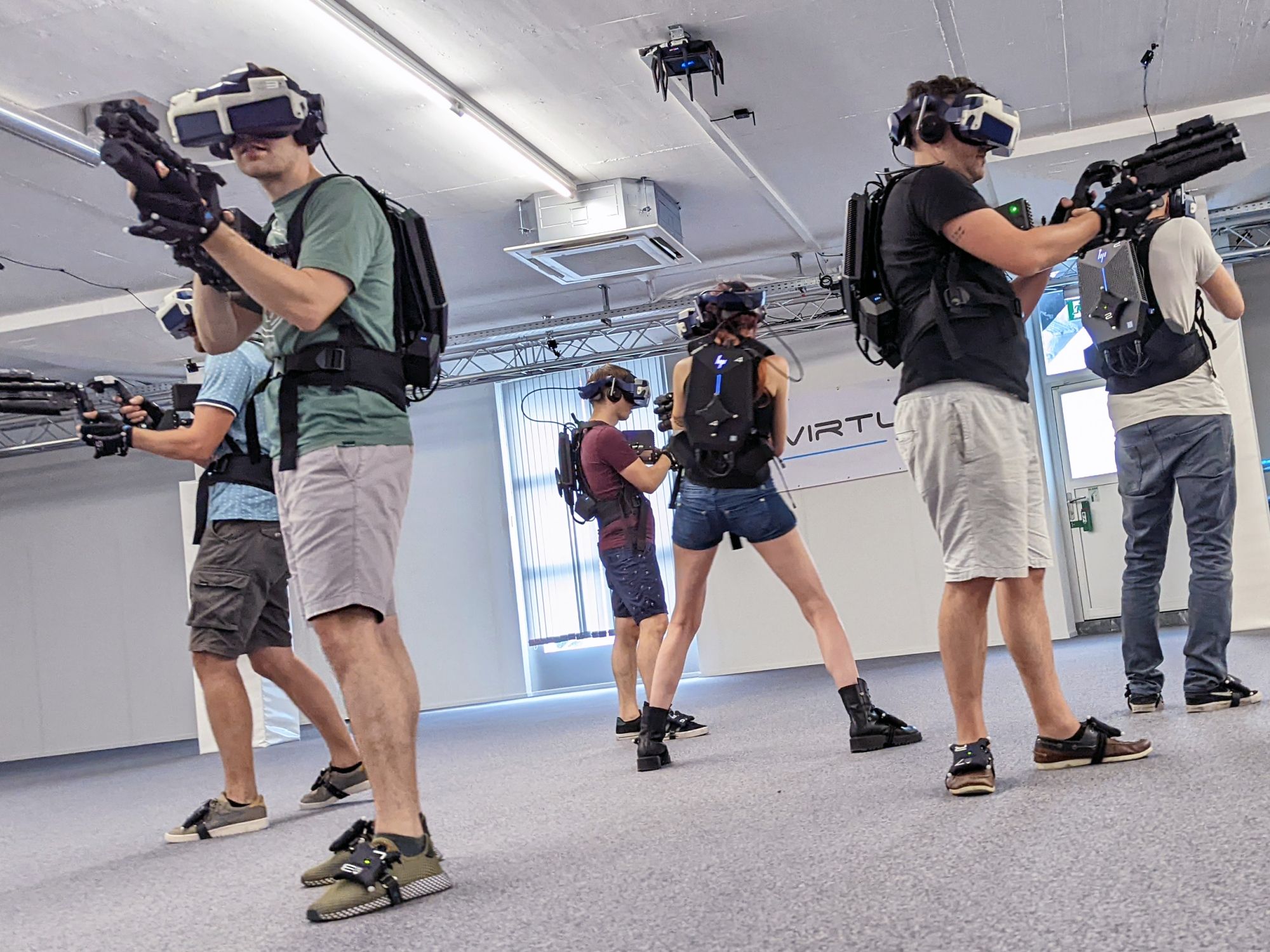 VRゲーム：グループは最新のゲームセンターでバーチャルリアリティを利用して一緒にプレイします。