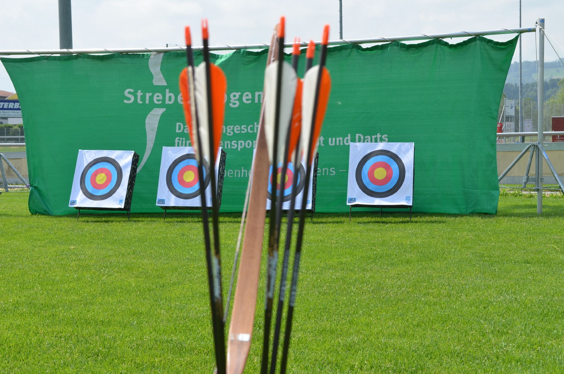Стрельба из лука в Швейцарии с стрелами перед мишенями на зелёной траве