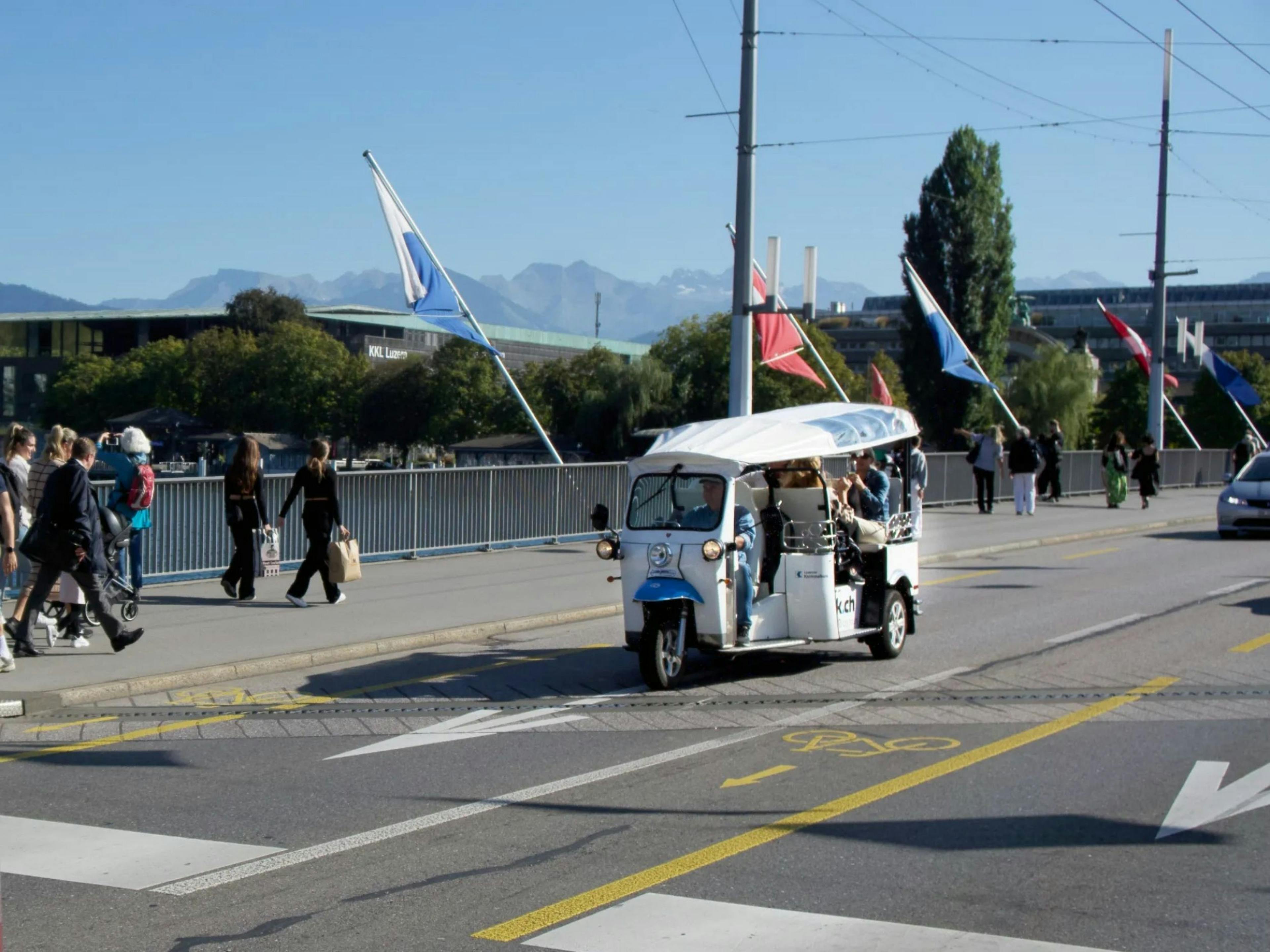 Tuk Tuk: Verkehr auf der Seebrücke mit Aussicht auf die Berge und fröhlichen Menschen.