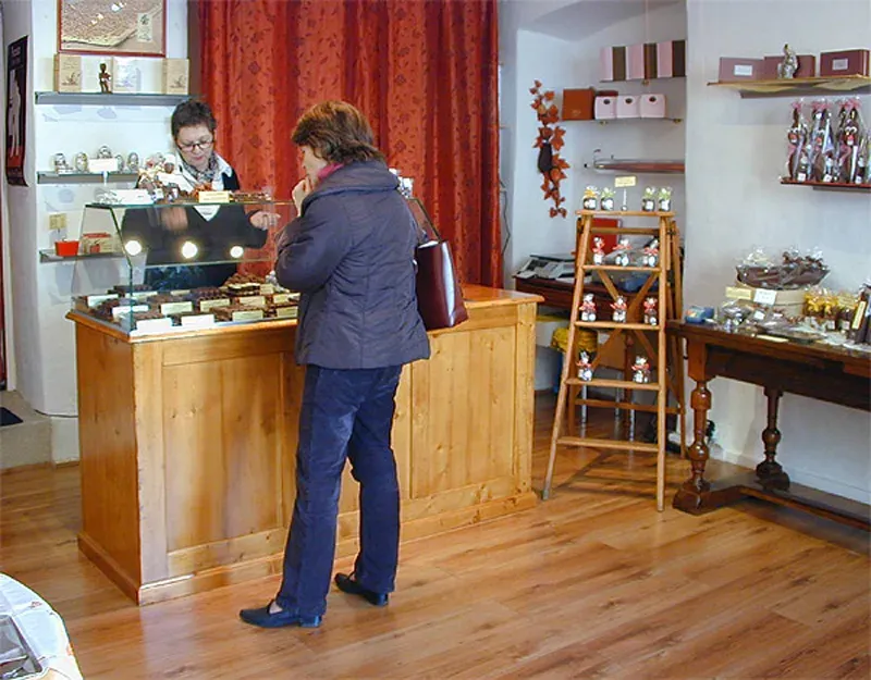 Chokolade- og konfektionsudstillingsområde i Moret, chokoladesorter, salgsdisken, hyggeligt interiør.