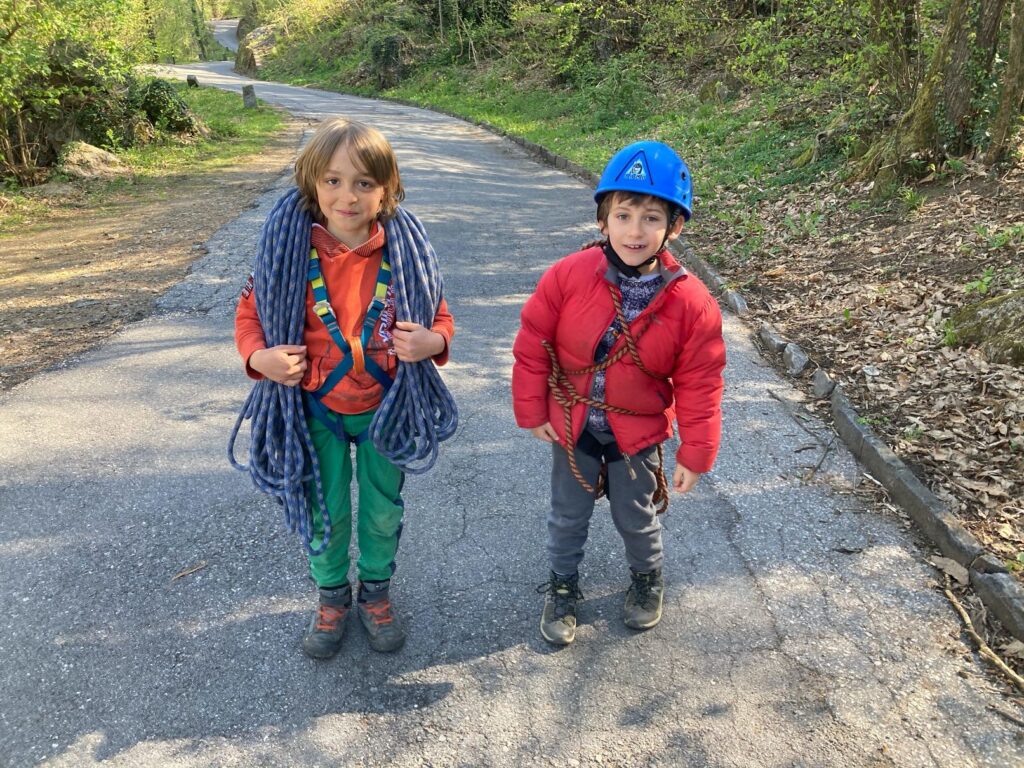 تسلق العائلات مع الأطفال في الهواء الطلق، مغامرة في الطبيعة، نشاط صيفي، متعة جماعية.