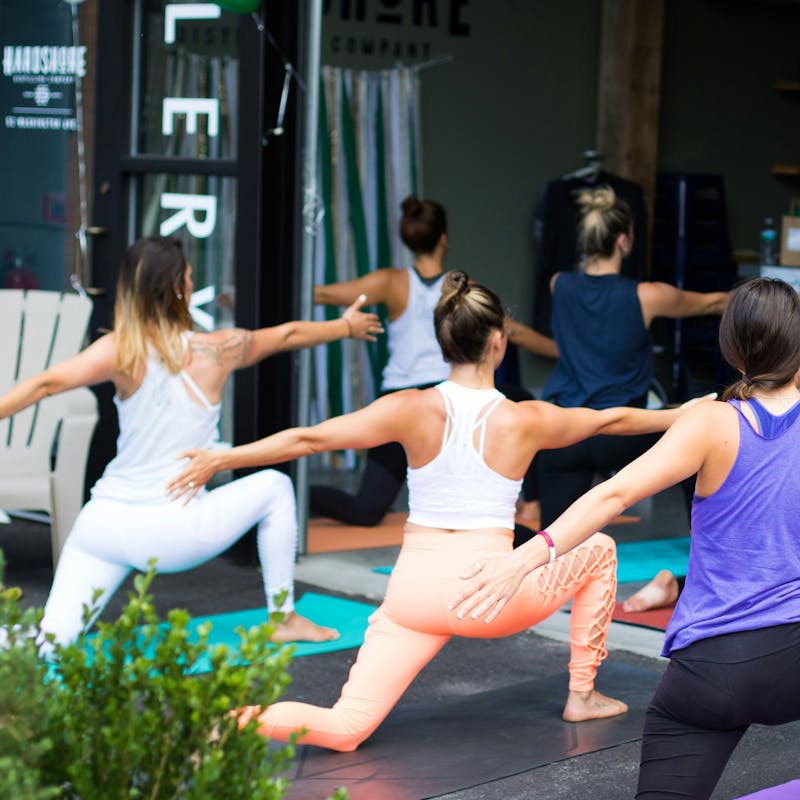 Йога: група виконує розслаблюючі вправи на свіжому повітрі влітку