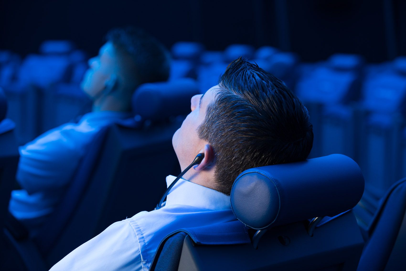 Divadelní sál návštěvník odpočívá s sluchátky v modném osvětlení
