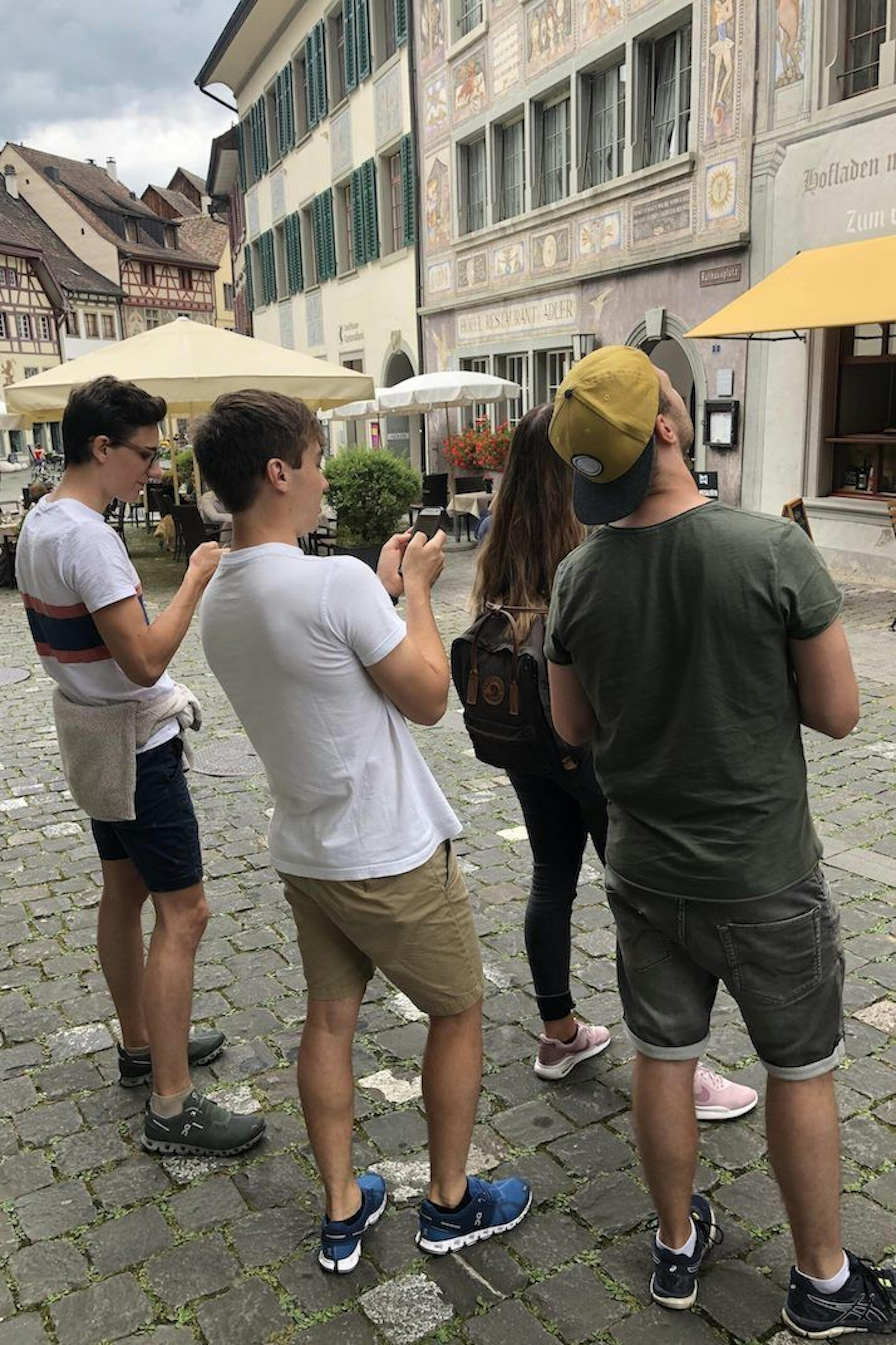 Caça ao tesouro em St. Gallen, grupo de jogos observa fachadas históricas