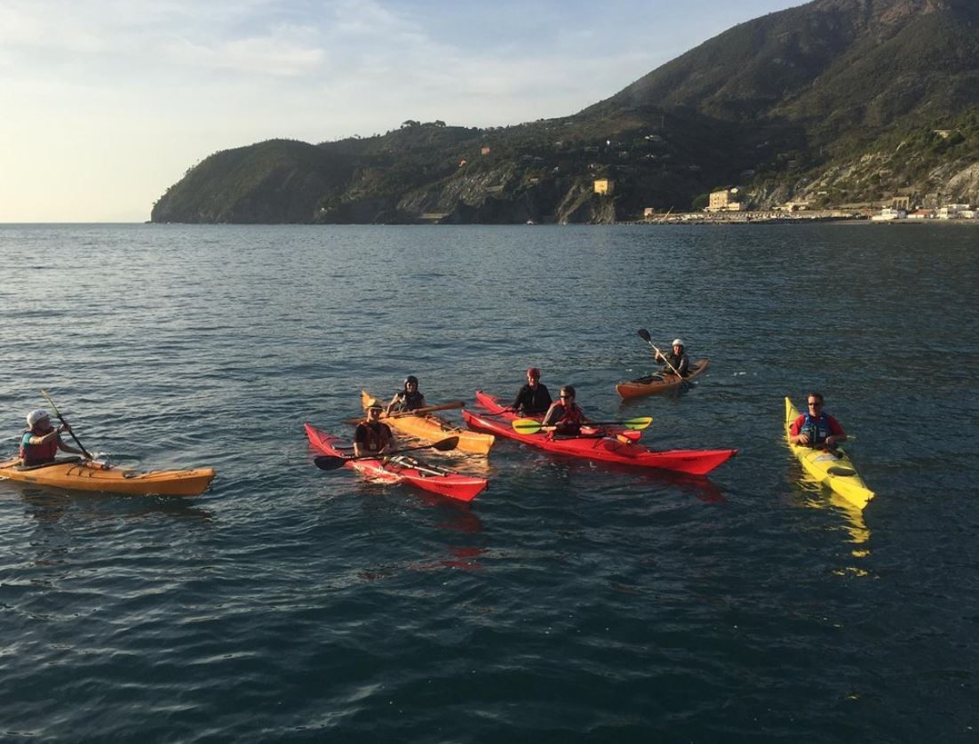 Sea kayaking in Cinque Terre in 2023 with several participants in colorful boats.
