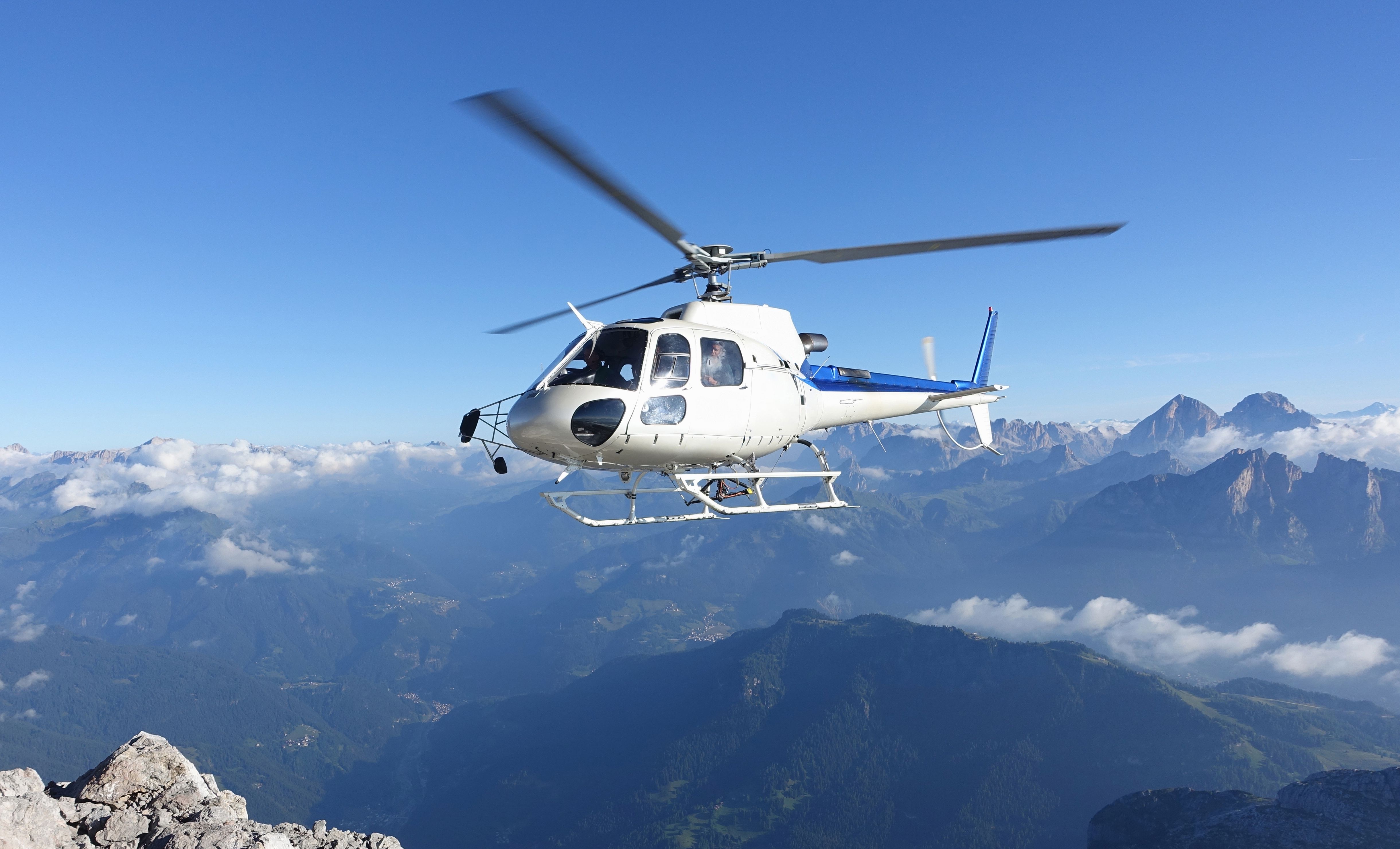Helicopter flight Valais over the Alps with views of mountain landscapes and clouds.