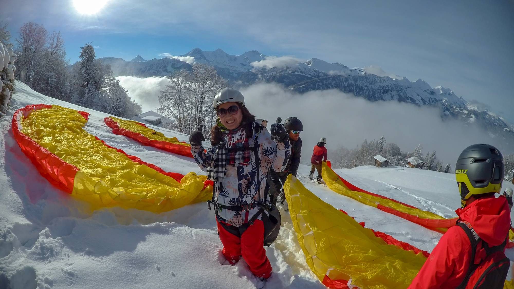 Aktivitas payung terjun musim dingin di salju saat cerah matahari.
