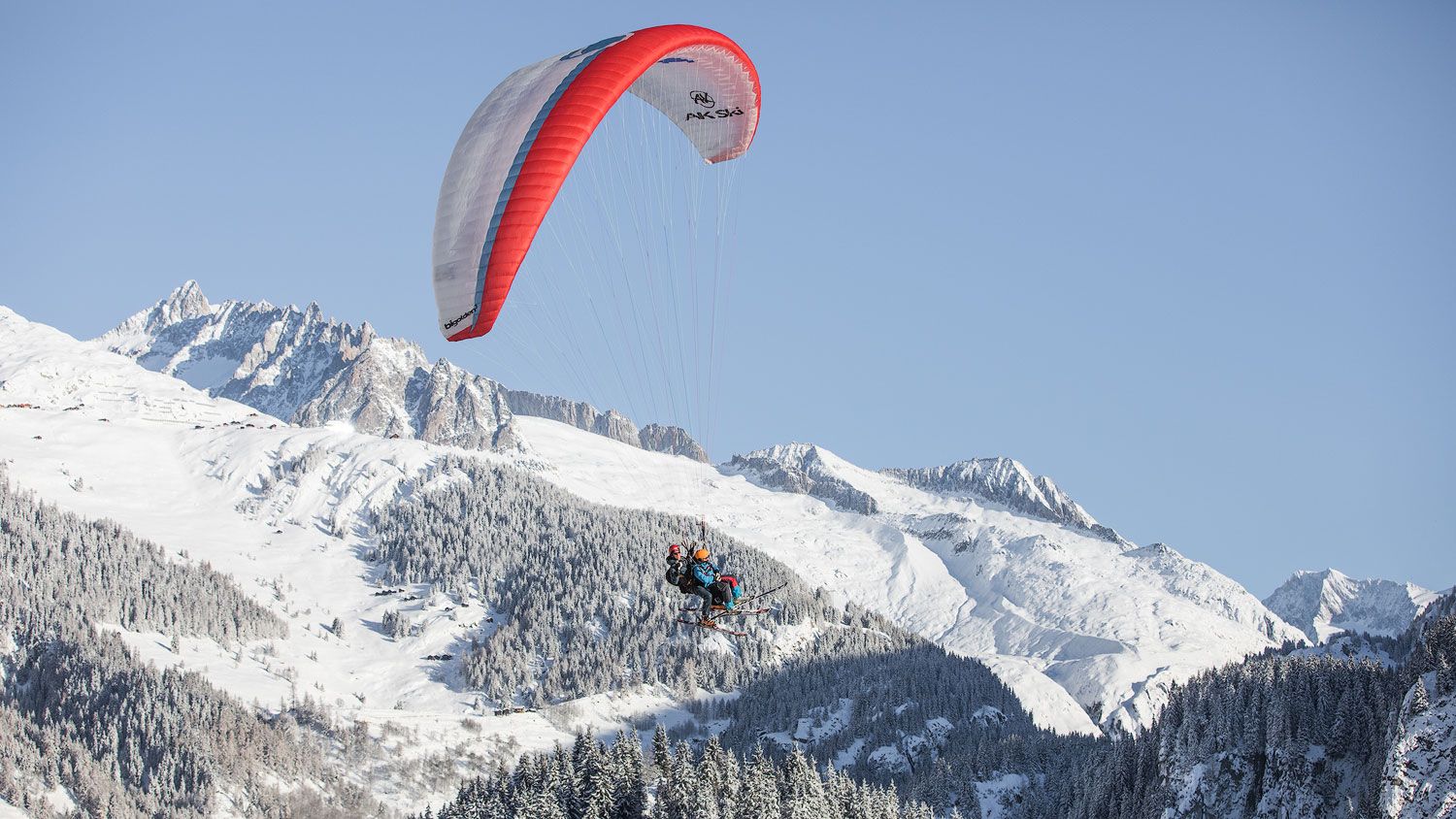 Skärmflygning över snötäckta berg i skidorten, klar sikt