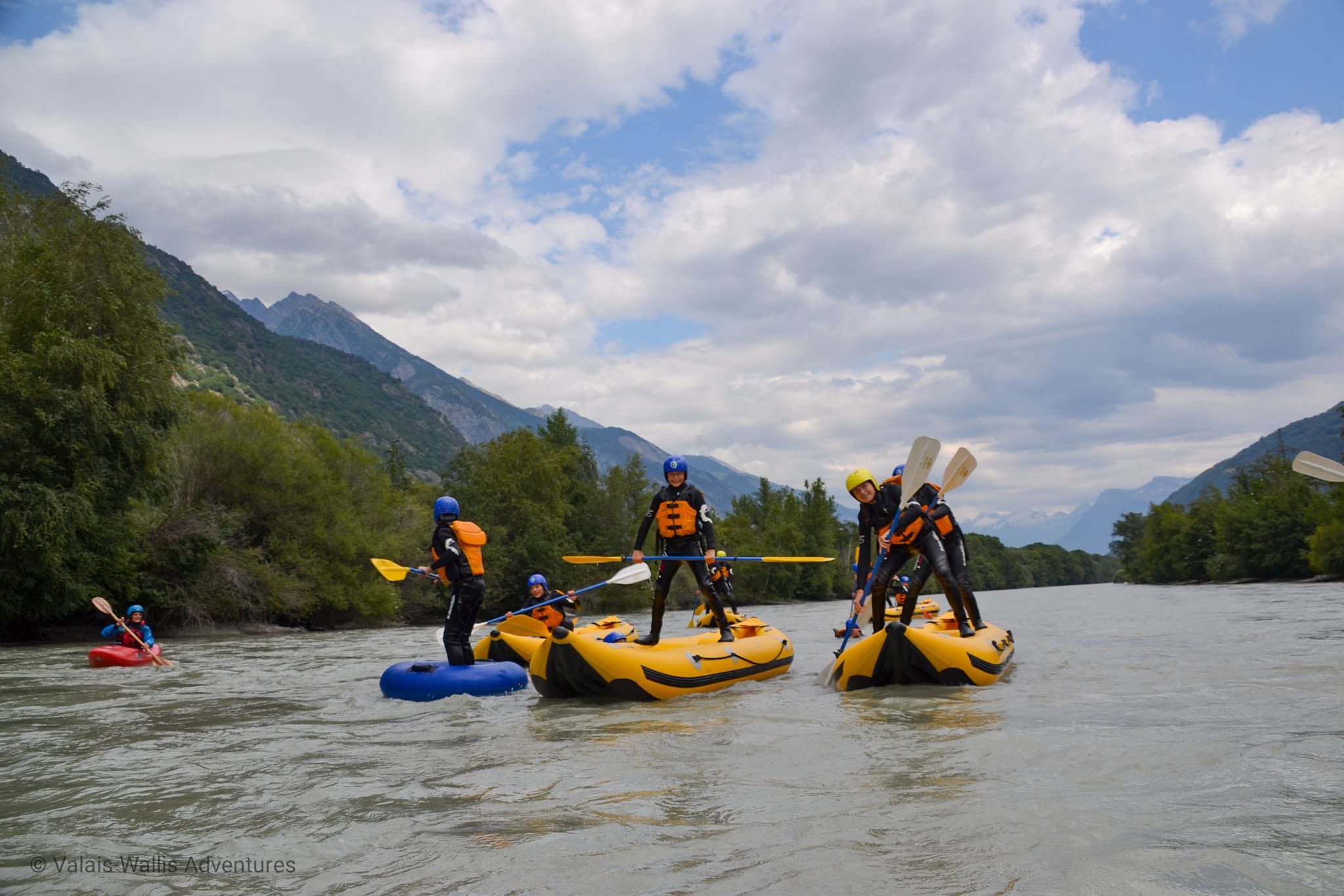 Tour de Funyak dans le Valais. Le groupe pagaye dans des bateaux jaunes en pleine nature.