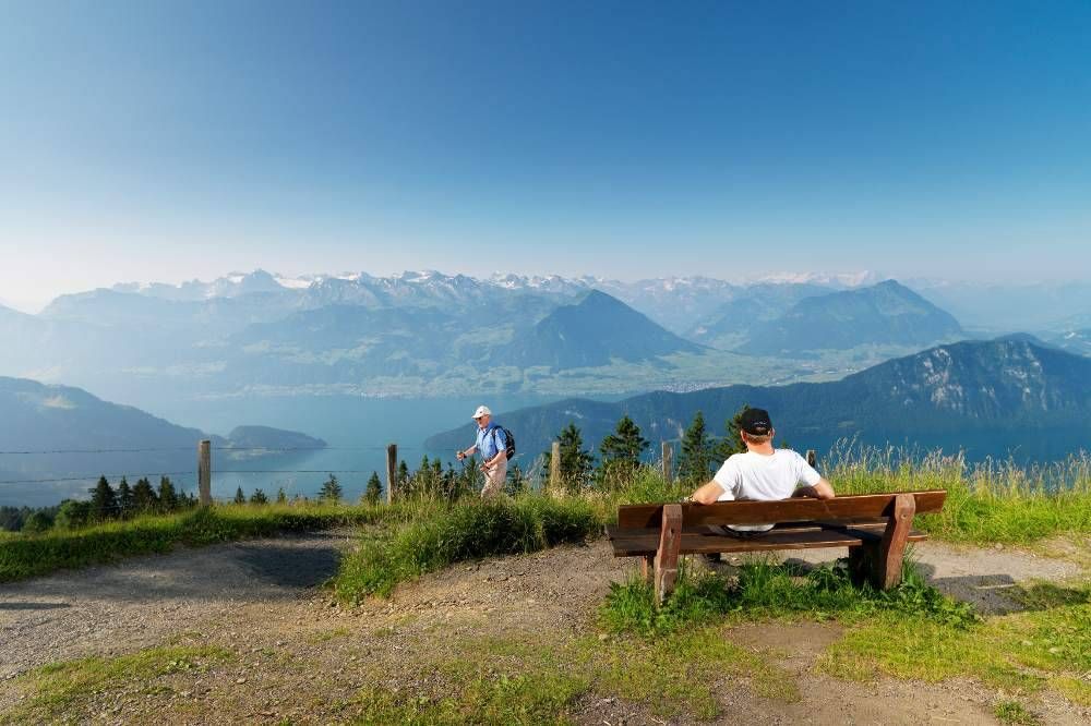 การทัศนศึกษาที่ Rigi พร้อมวิวทะเลสาบ Vierwaldstättersee, นักเดินป่าบนม้านั่ง, ท้องฟ้าที่ใส