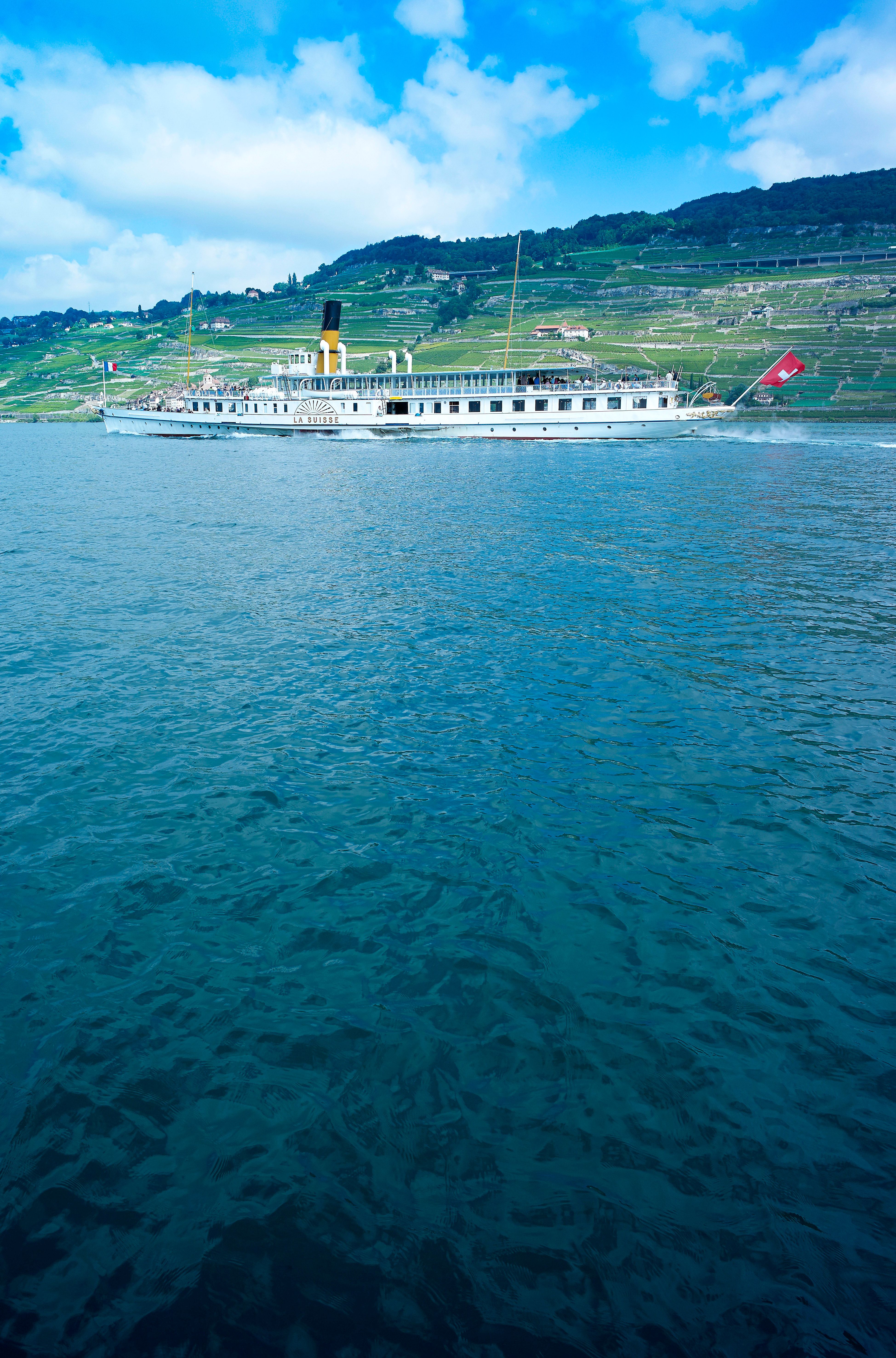 Navigazione sul Lago di Ginevra, nave a vapore sull'acqua, vigneti, cielo azzurro