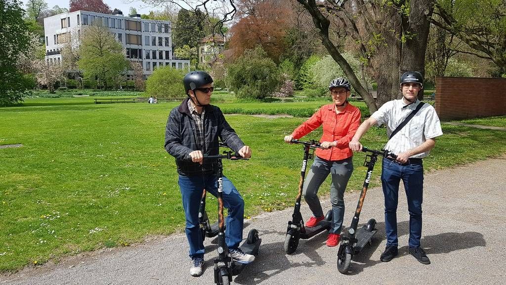 苏黎世电动滑板车游，在阳光明媚的公园里与参与者一起。