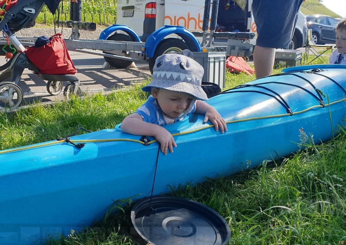 Child canoeing in nature with sun