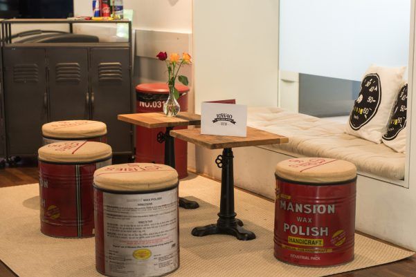 ケーキ・エスケープの居心地の良いシーティングエリア、古い缶で作ったスツールとカフェのテーブル。