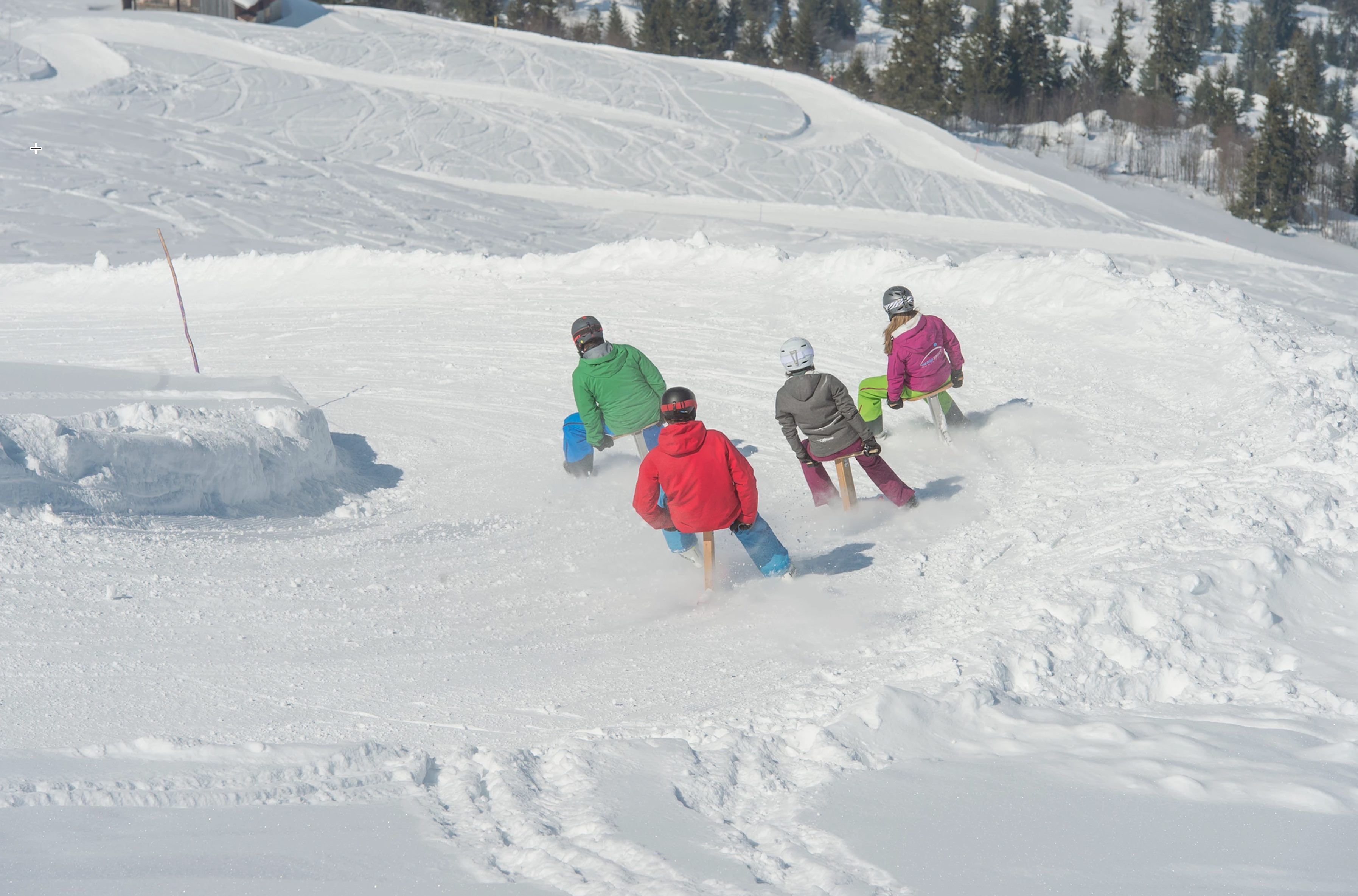 Famille en train de faire de la luge à la Tschentenalp en hiver