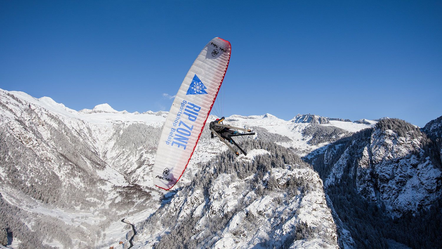 Paragliding över snötäckta berg i Rosswald
