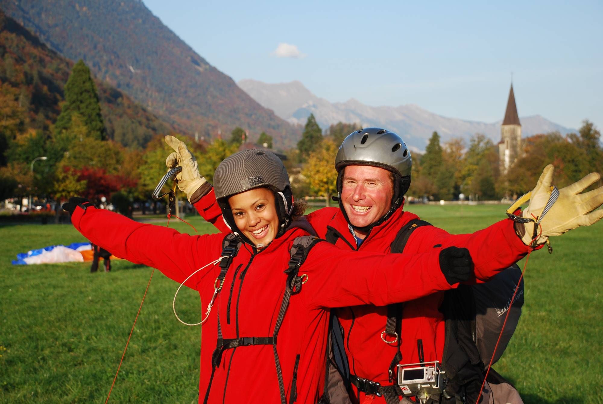 Tandemhopp i Interlaken med två personer i röda jackor, bergig omgivning