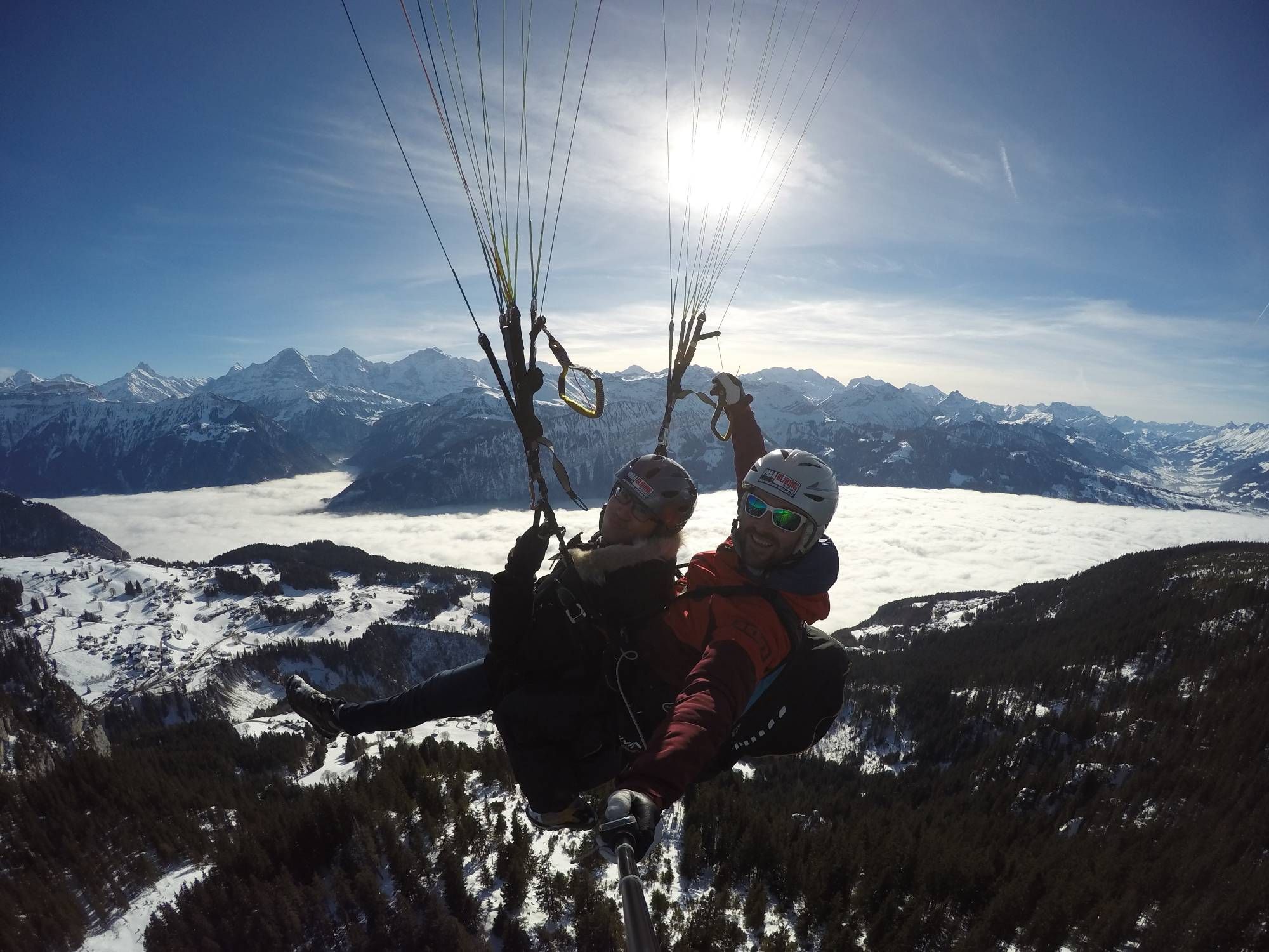 Paralayang Tandem Musim Dingin di atas pegunungan Alpen di Oberland, pemandangan musim dingin dengan salju.