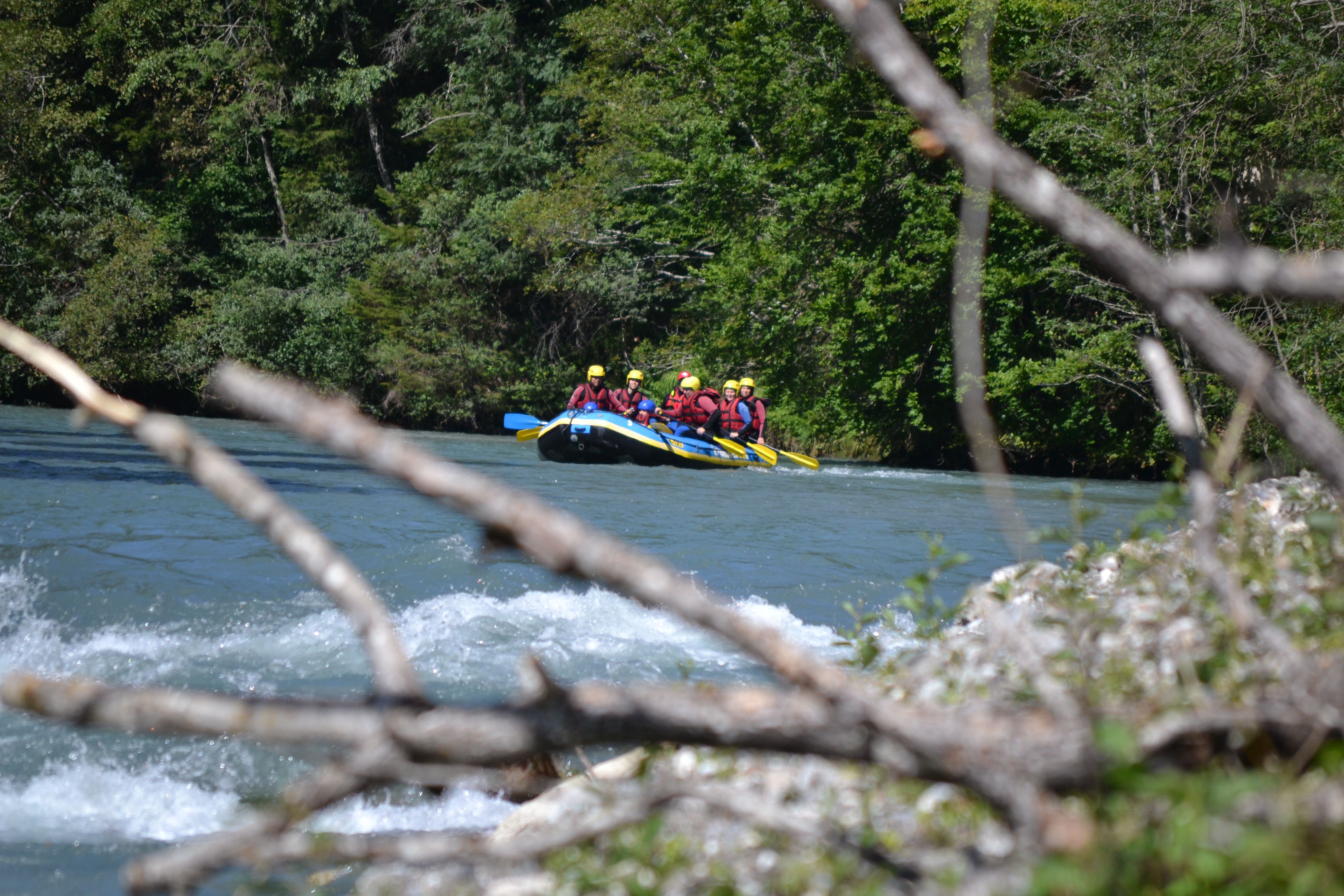 Rafting Sungai Switzerland dengan orang yang mendayung di sungai, persekitaran hijau.