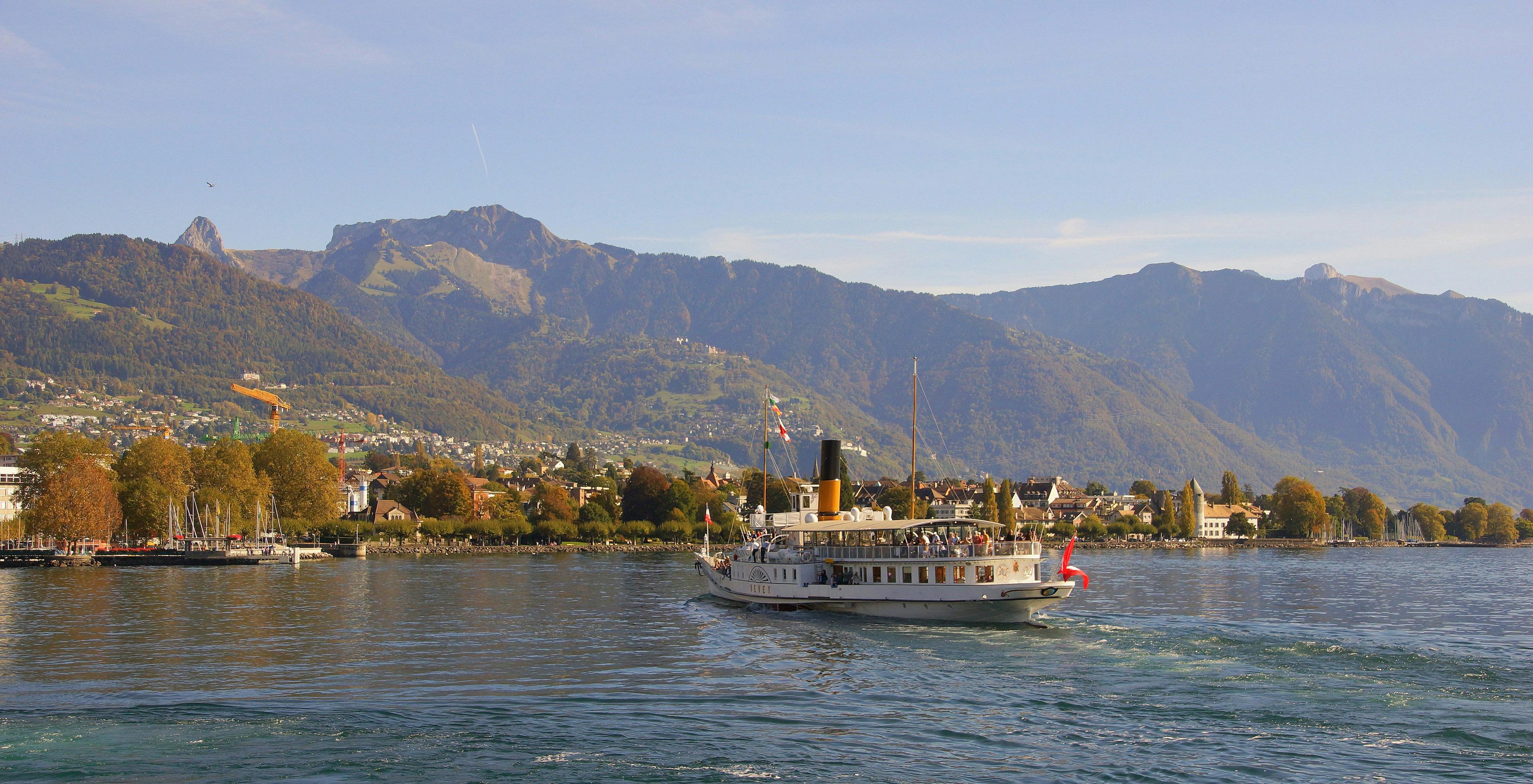 Riviera Tour Genfersee Schiff auf dem Wasser mit Bergen im Hintergrund.